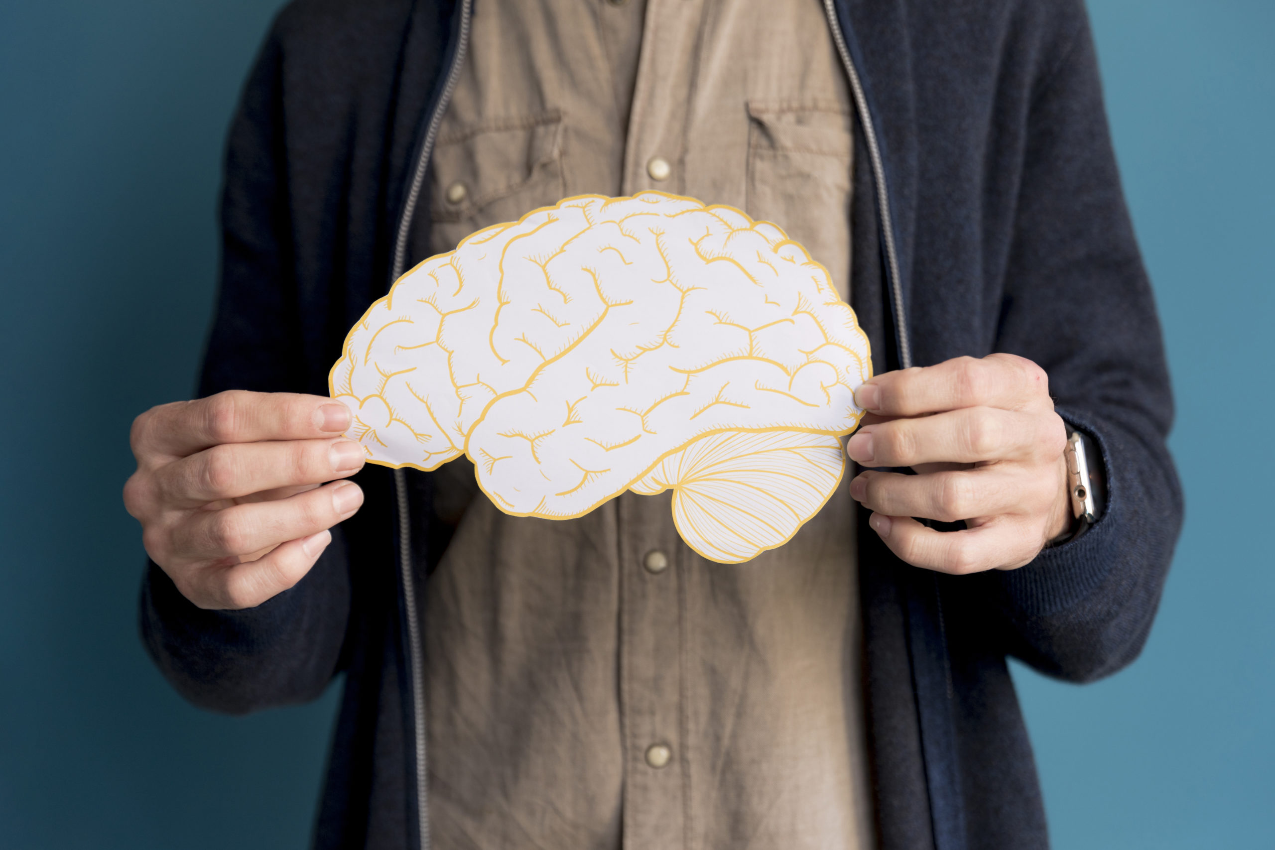 close-up-man-holding-paper-brain